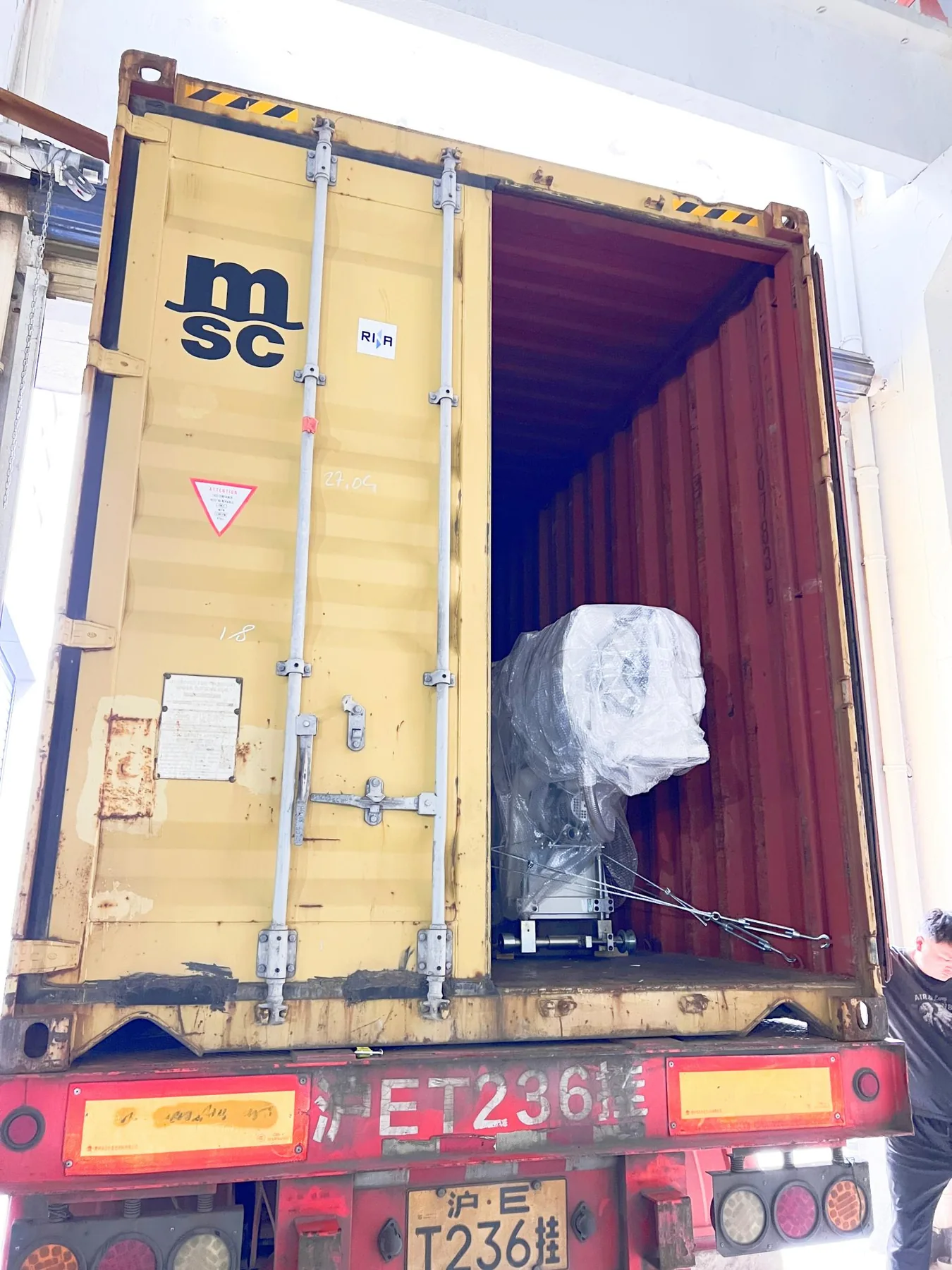 Loaded machinery visible through the open container doors